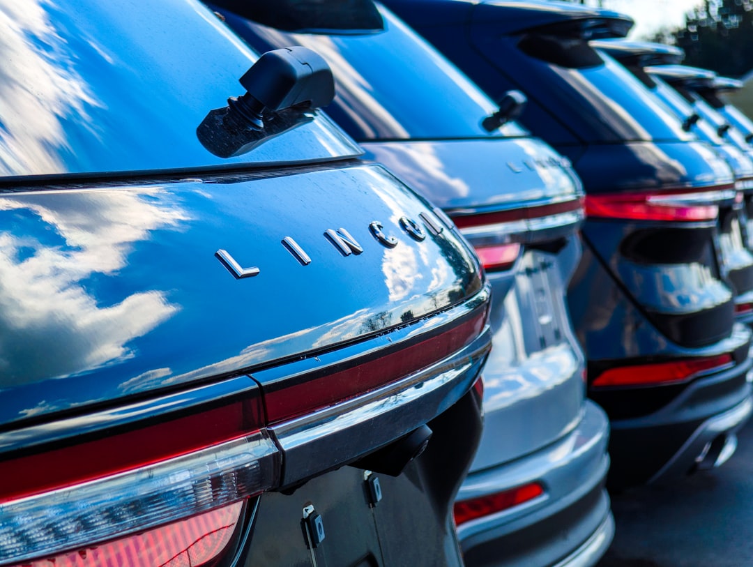 Row of shiny black lincoln suvs reflecting the sky